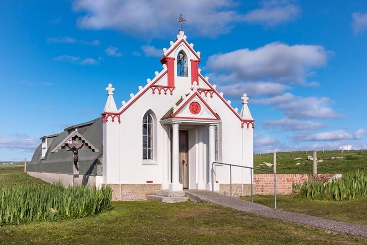 una petita església blanca amb un campanar en un camp