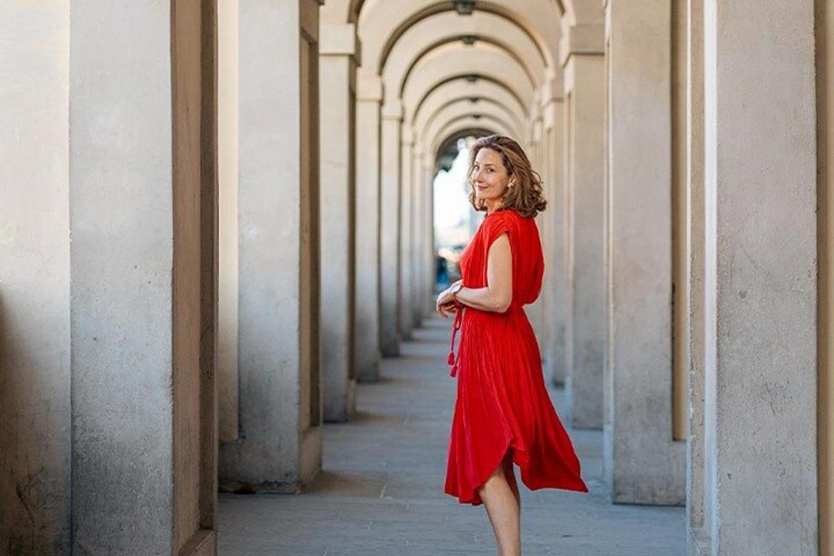 Una mujer con un vestido rojo caminando por un pasillo.
