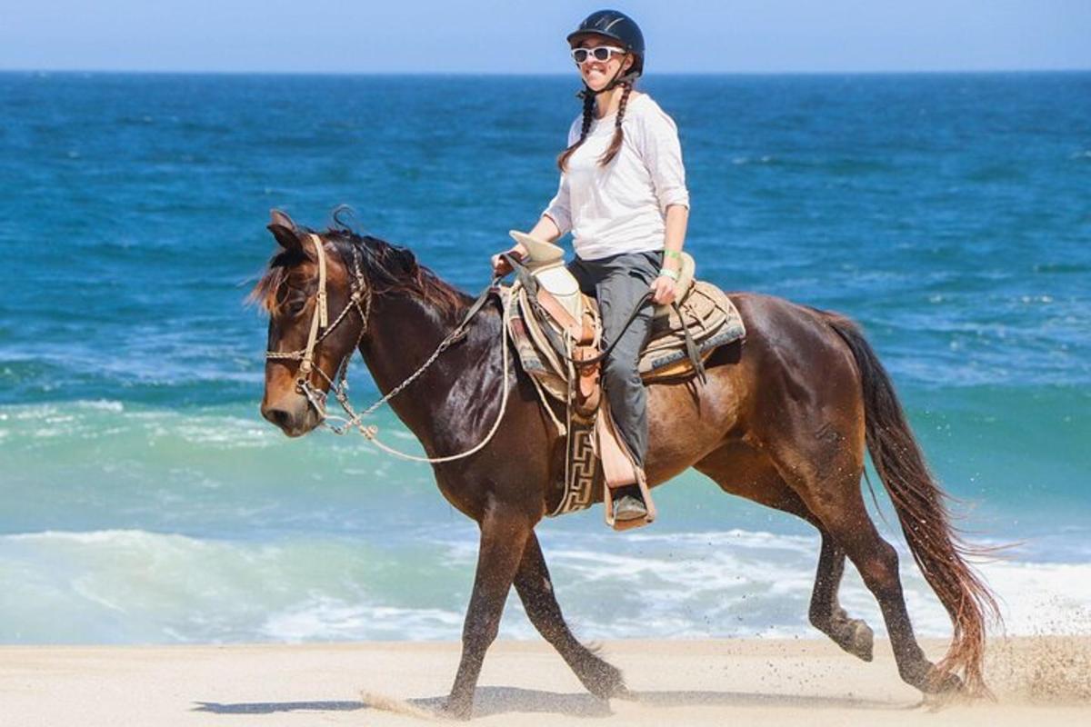 una dona muntant a cavall a la platja