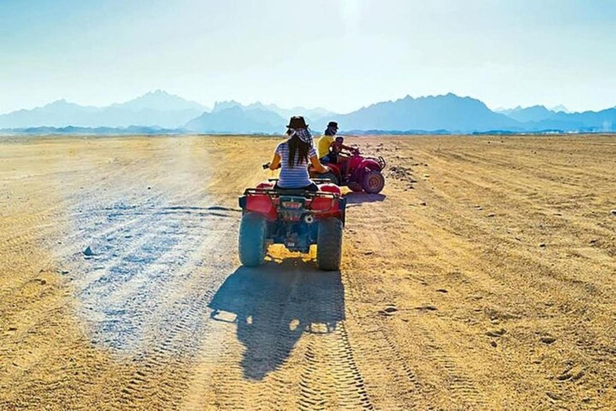 Dos personas viajando en vehículos todo terreno en un campo de tierra