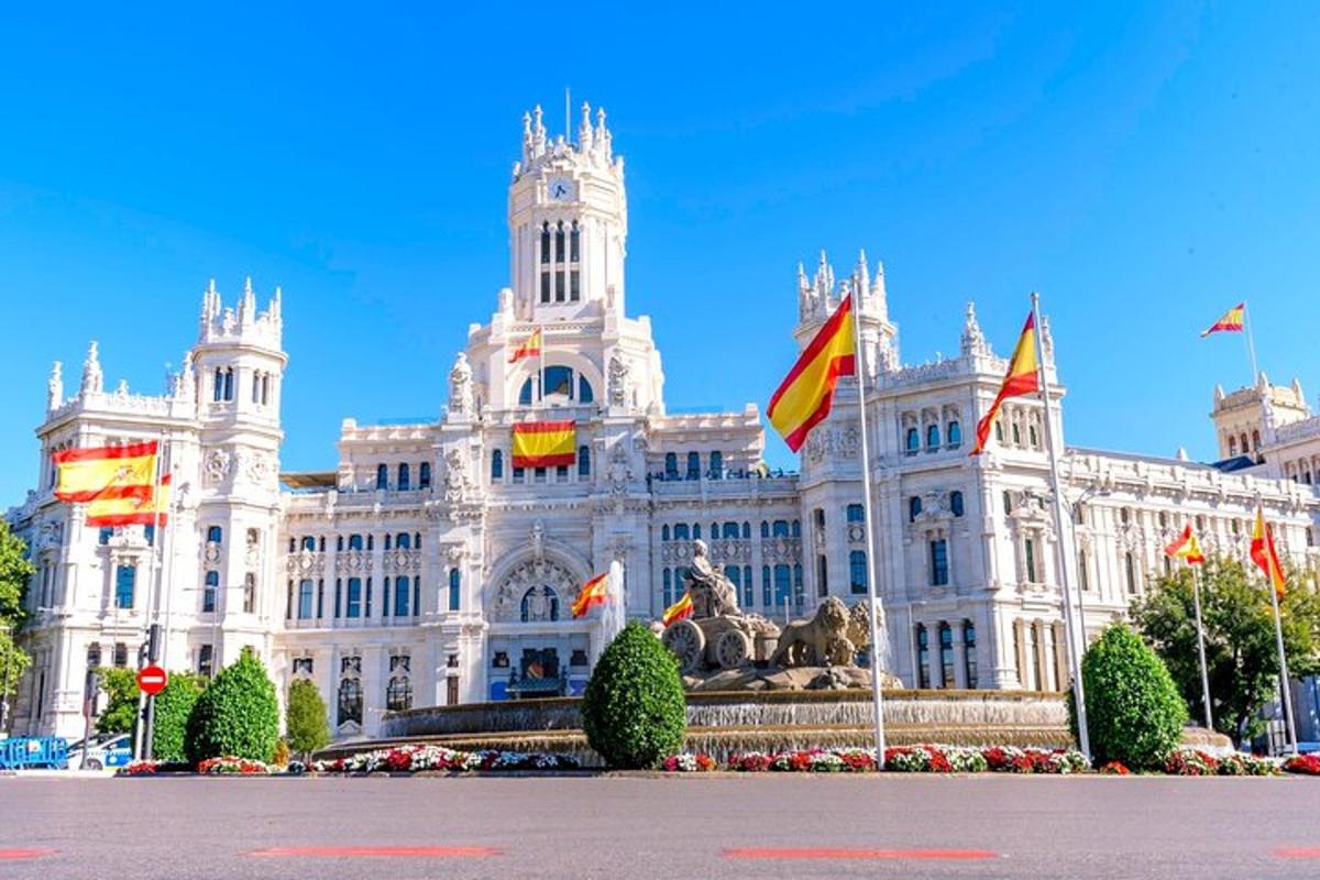 um grande edifício branco com bandeiras na frente