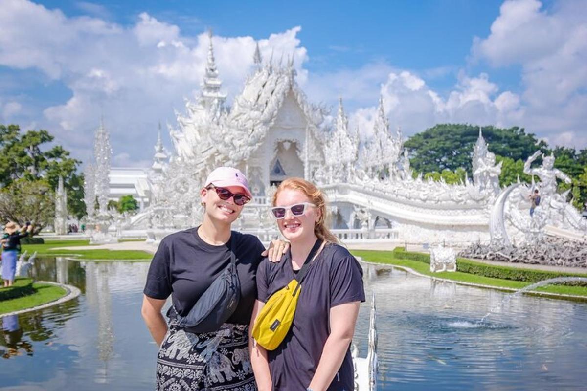 a man and woman standing in front of a white temple