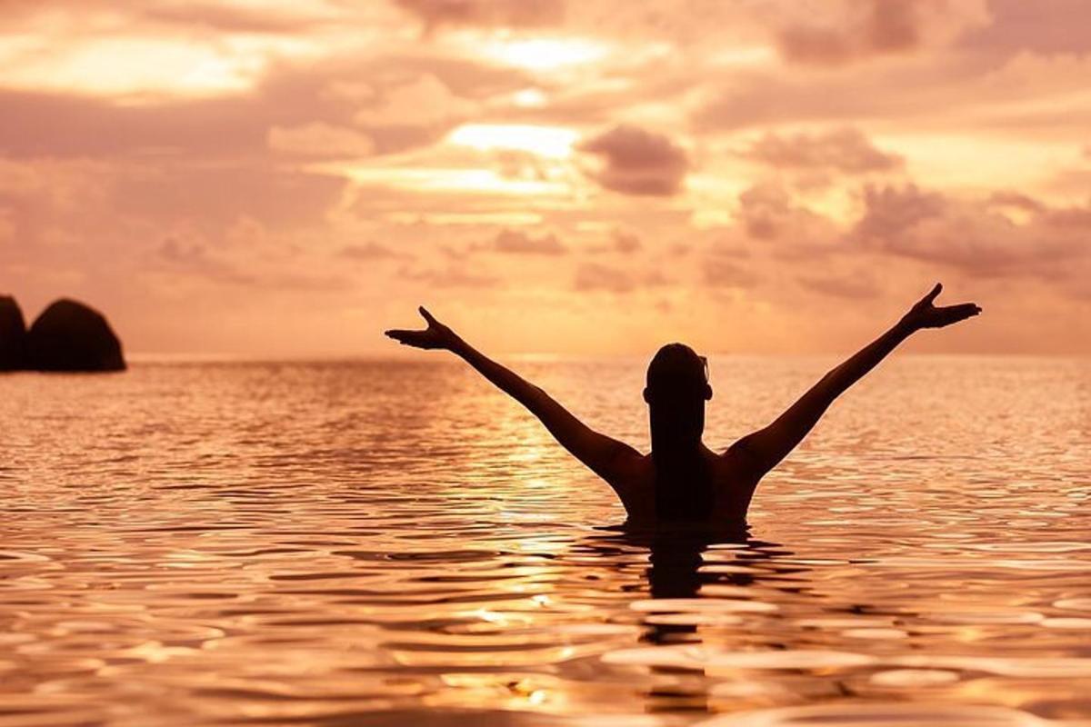una donna in acqua con le braccia tese