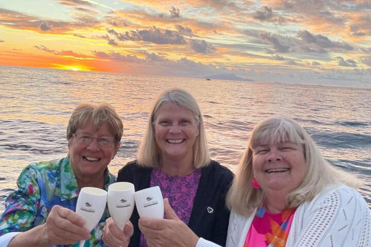tre donne posano per una foto sulla spiaggia al tramonto