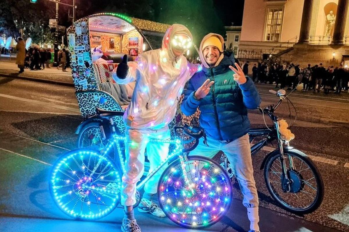 un uomo in piedi accanto a un uomo su una bicicletta con le luci