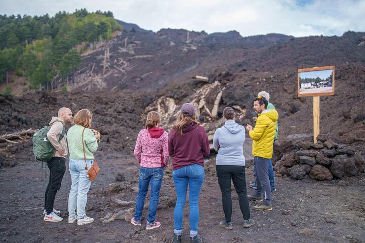 un gruppo di persone in piedi accanto a un cartello su una montagna
