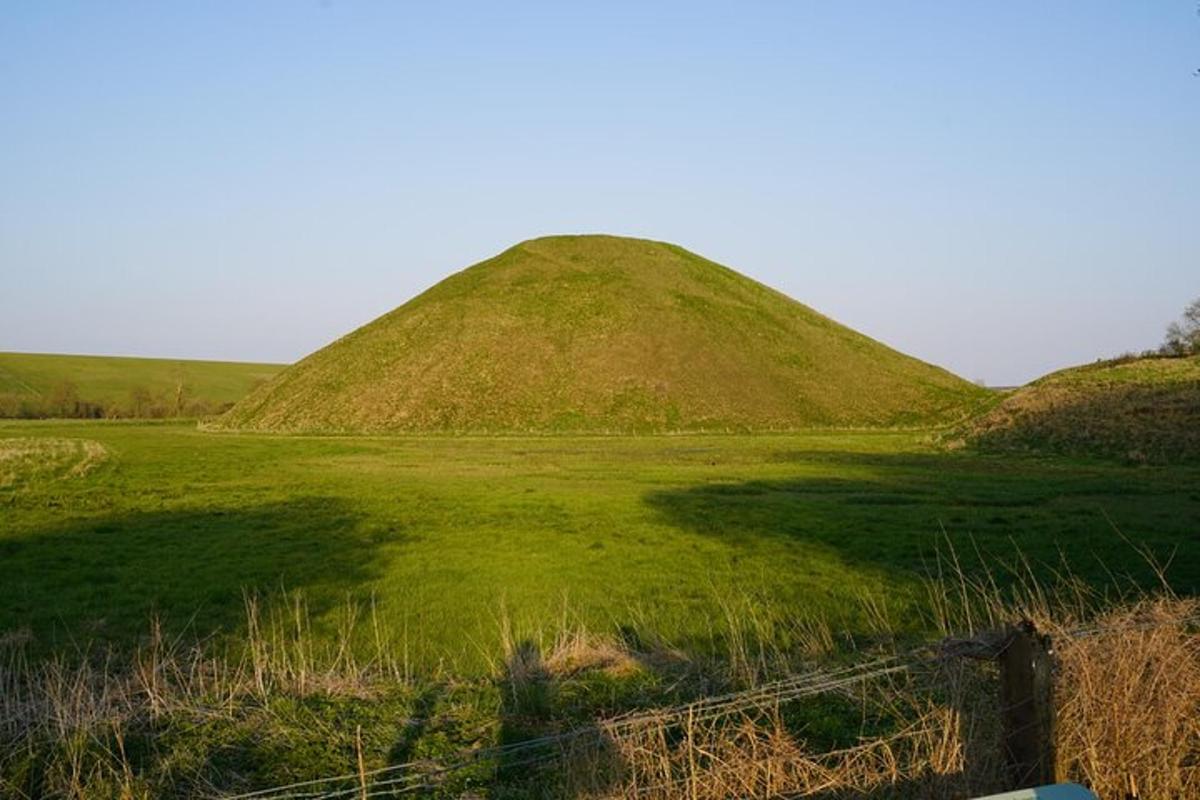 un campo con due grandi colline erbose con una recinzione