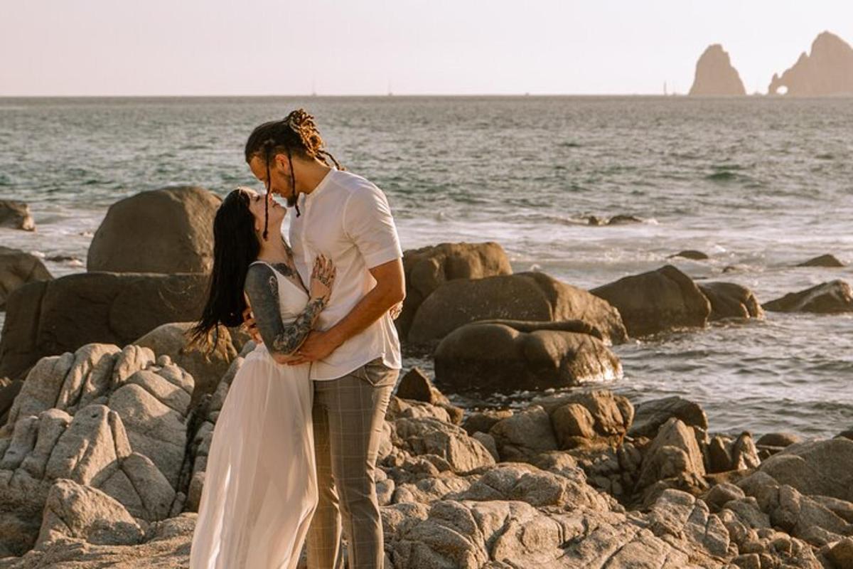 un uomo e una donna in piedi su una spiaggia rocciosa