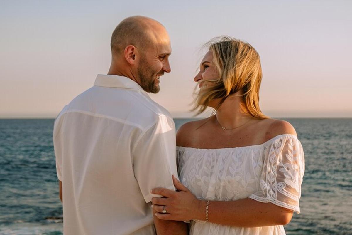 una sposa e uno sposo in piedi accanto all'oceano