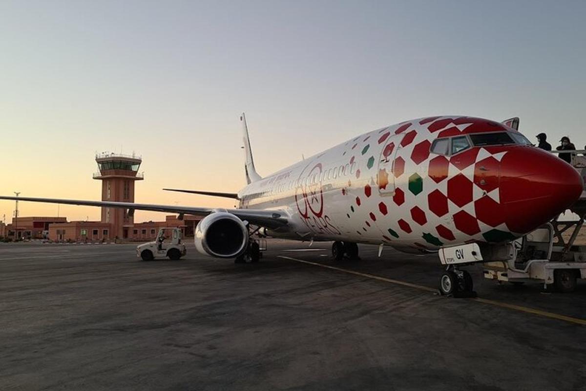 a red and white airplane sitting on the runway