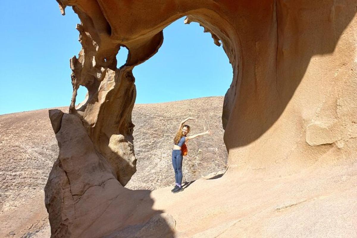 una donna in piedi in una grotta nel deserto