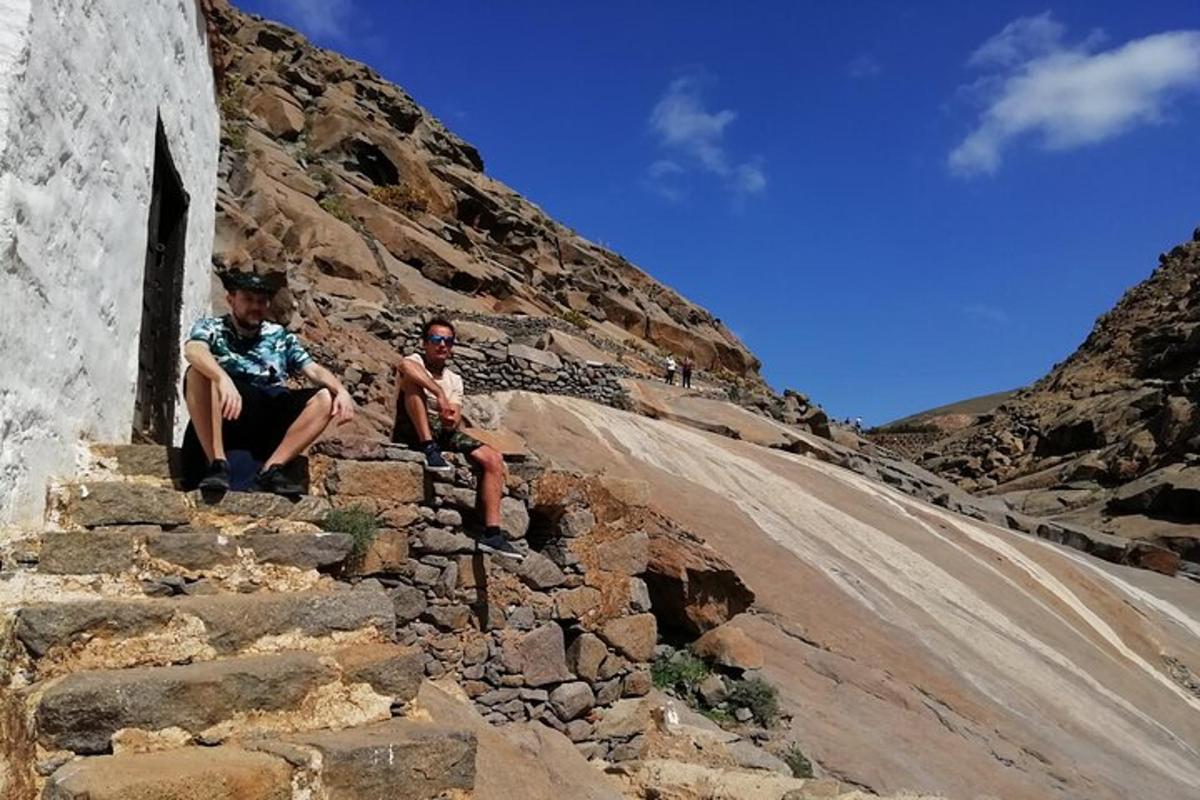 due uomini seduti sui gradini di una montagna