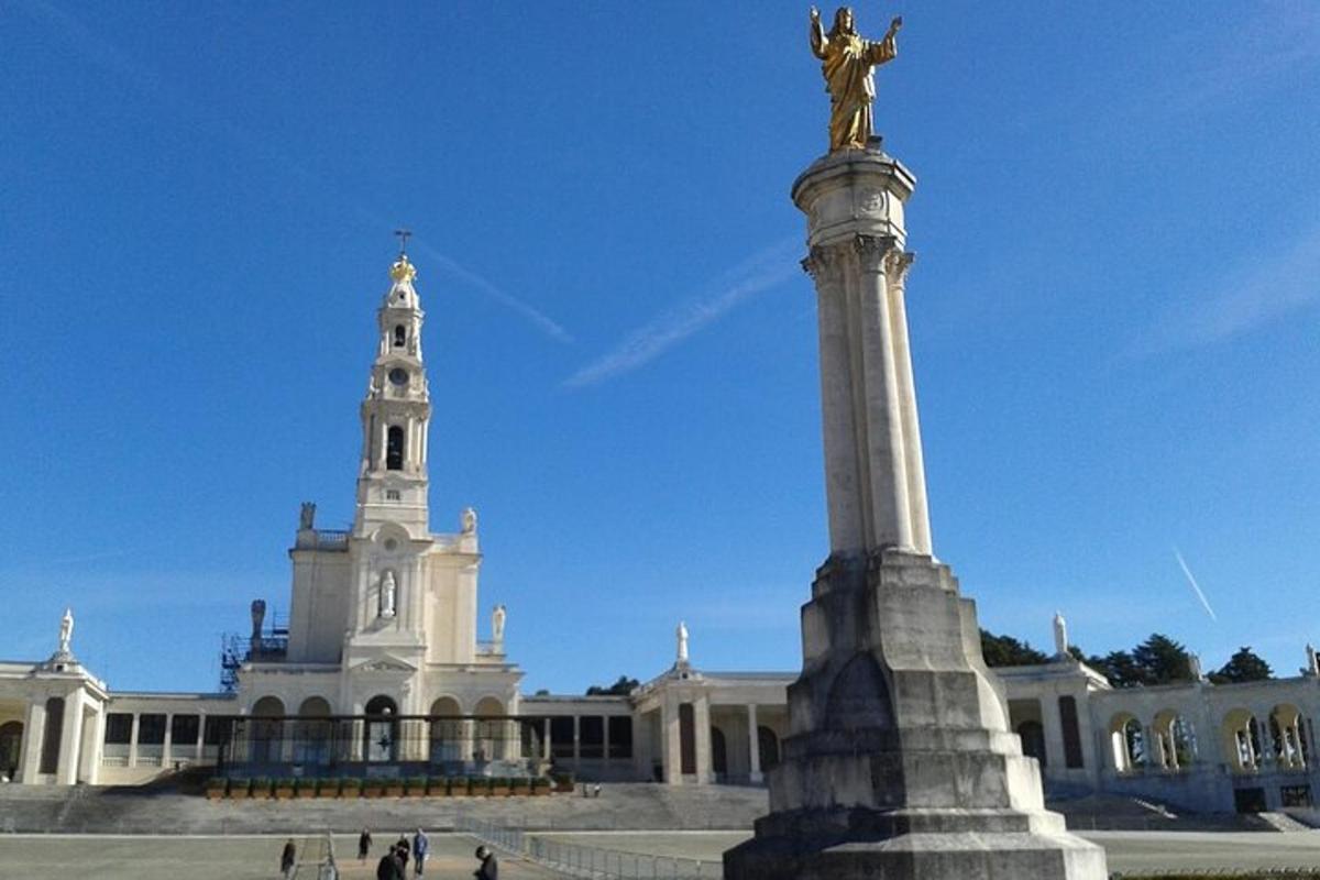 una estàtua davant d'un gran edifici amb una torre
