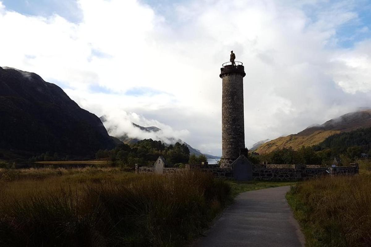 un faro con una croce in cima accanto a una strada