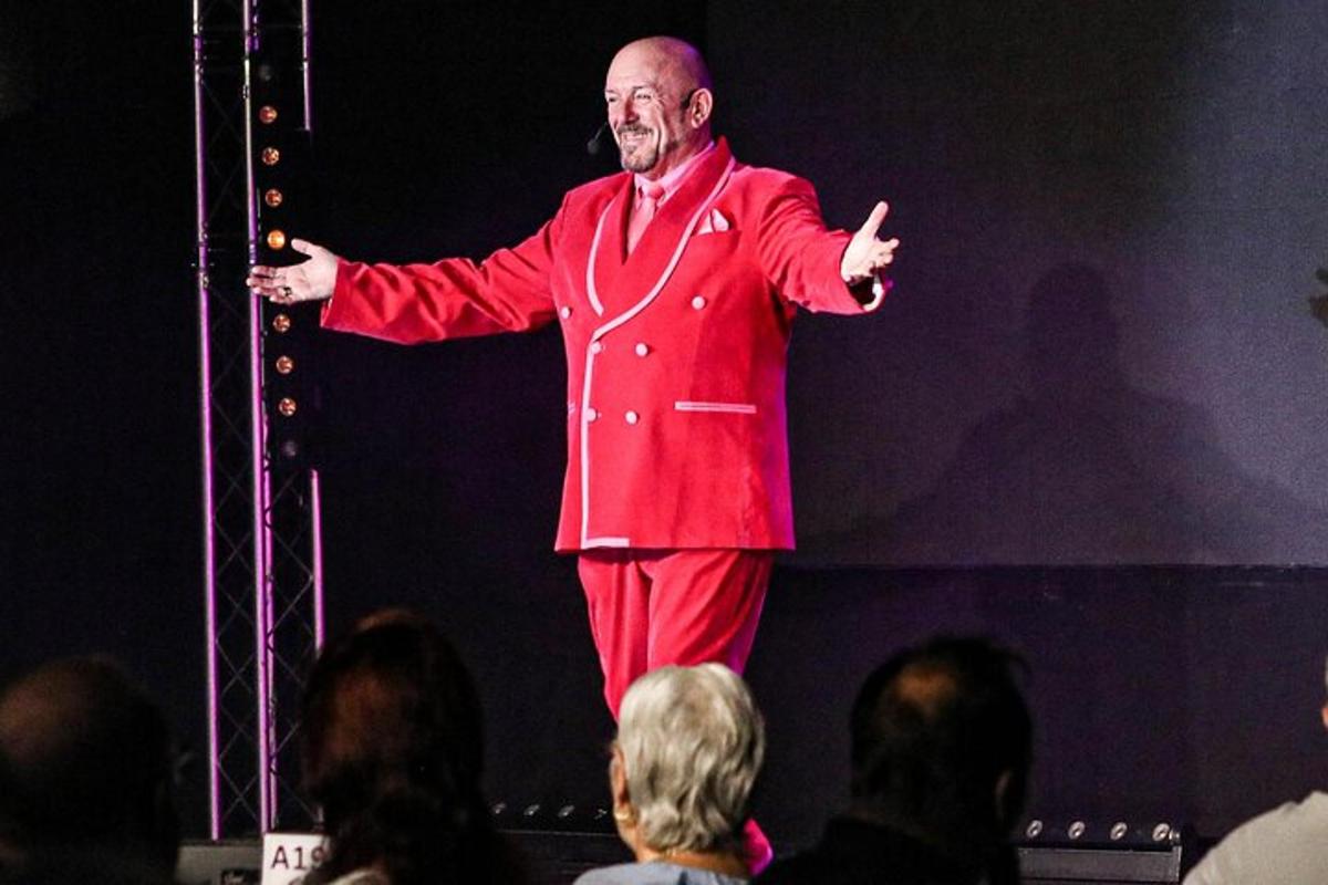 a man in a red suit standing on a stage