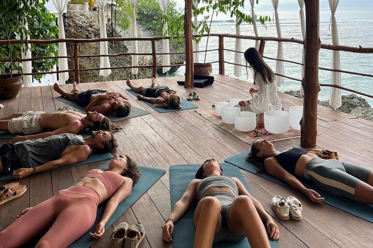 sekumpulan orang berbaring di atas lantai melakukan yoga
