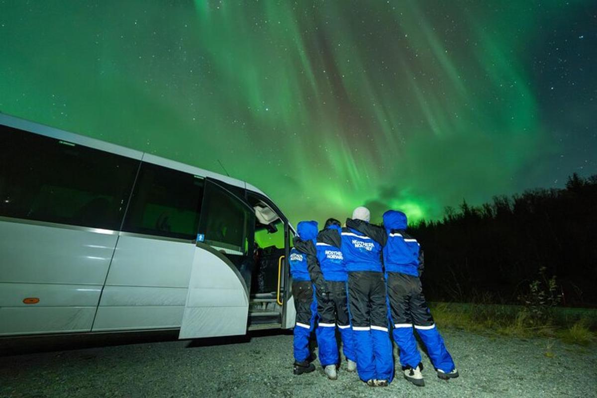 Un grupo de personas de pie frente a un autobús blanco.