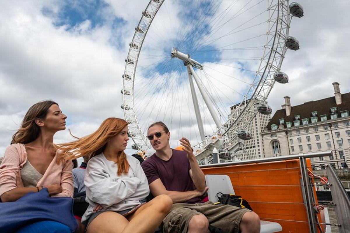 three people sitting on a boat in front of a ferris wheel