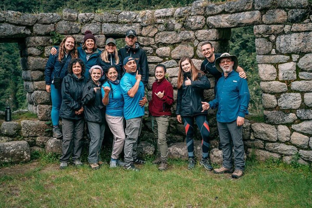 un gruppo di persone in piedi davanti a un muro di pietra