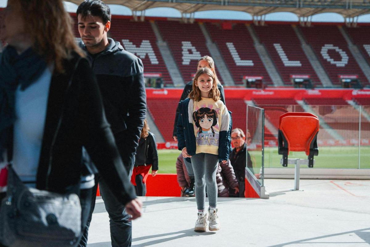una ragazza che cammina davanti a uno stadio