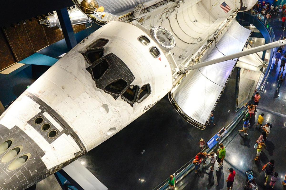 um grupo de pessoas em pé na frente de um ônibus espacial