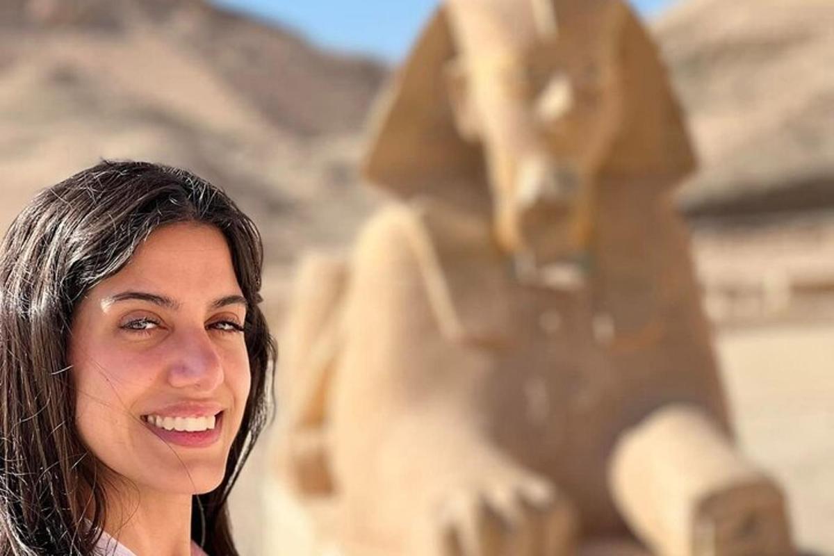 una donna è in piedi davanti a una statua
