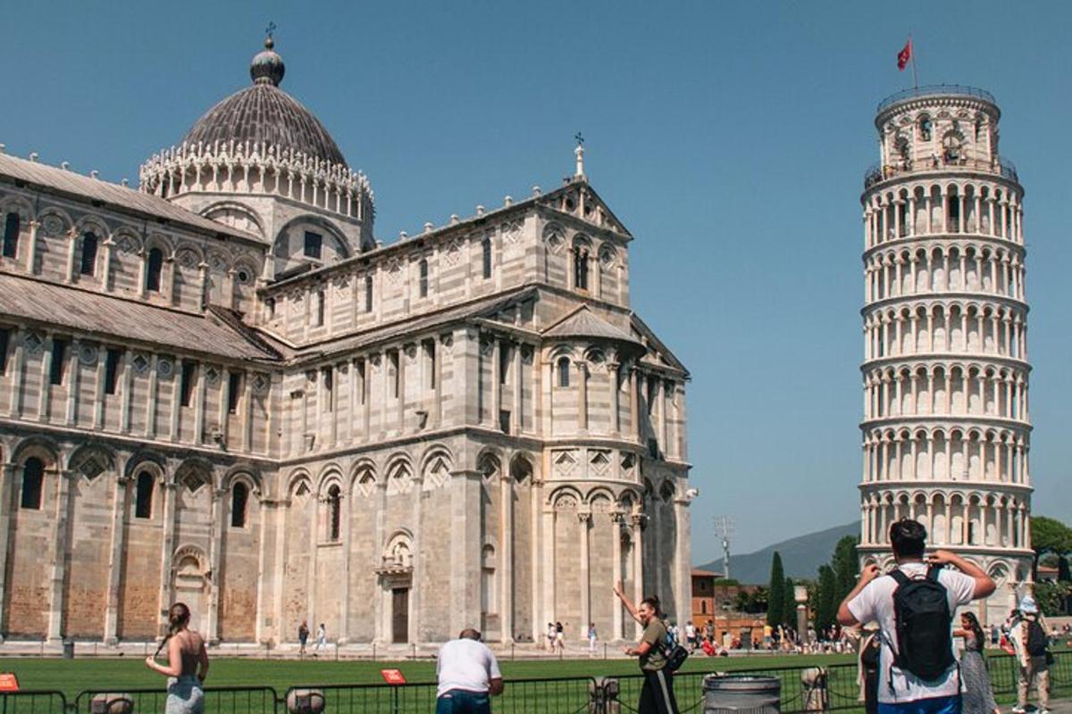 a man taking a picture of the leaning tower of cathedral