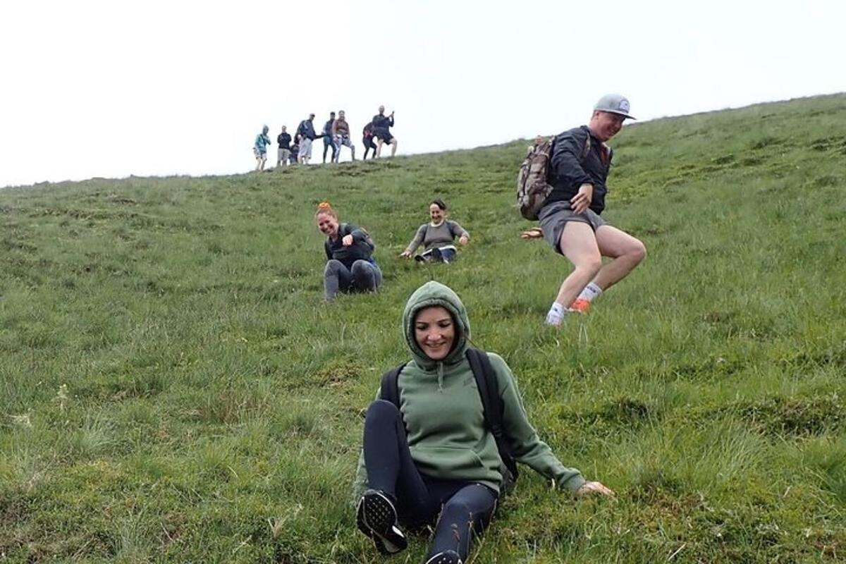 a group of people sitting on a grassy hill