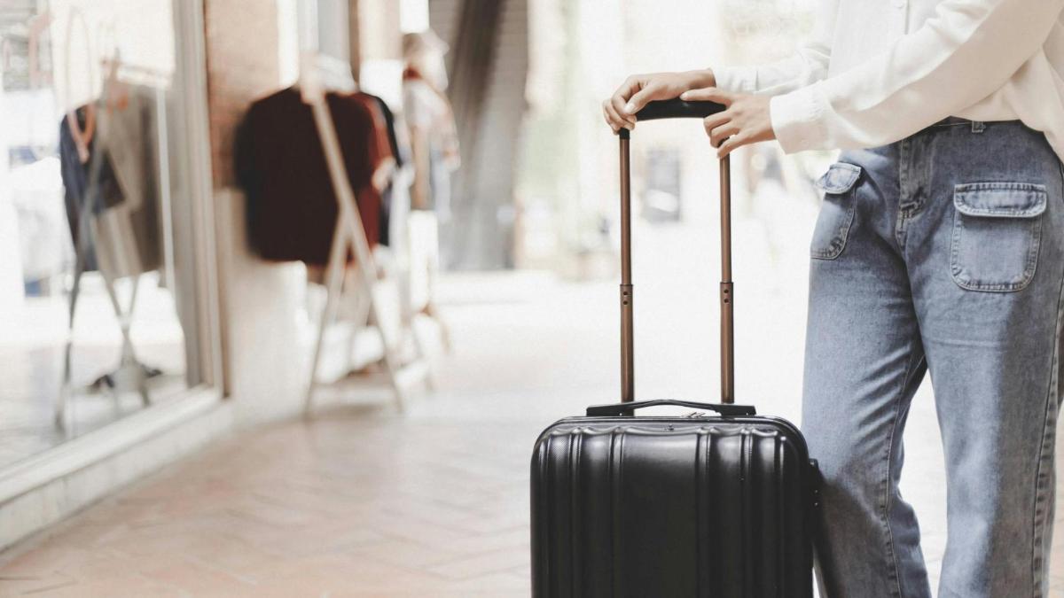 a woman is holding a suitcase in a store