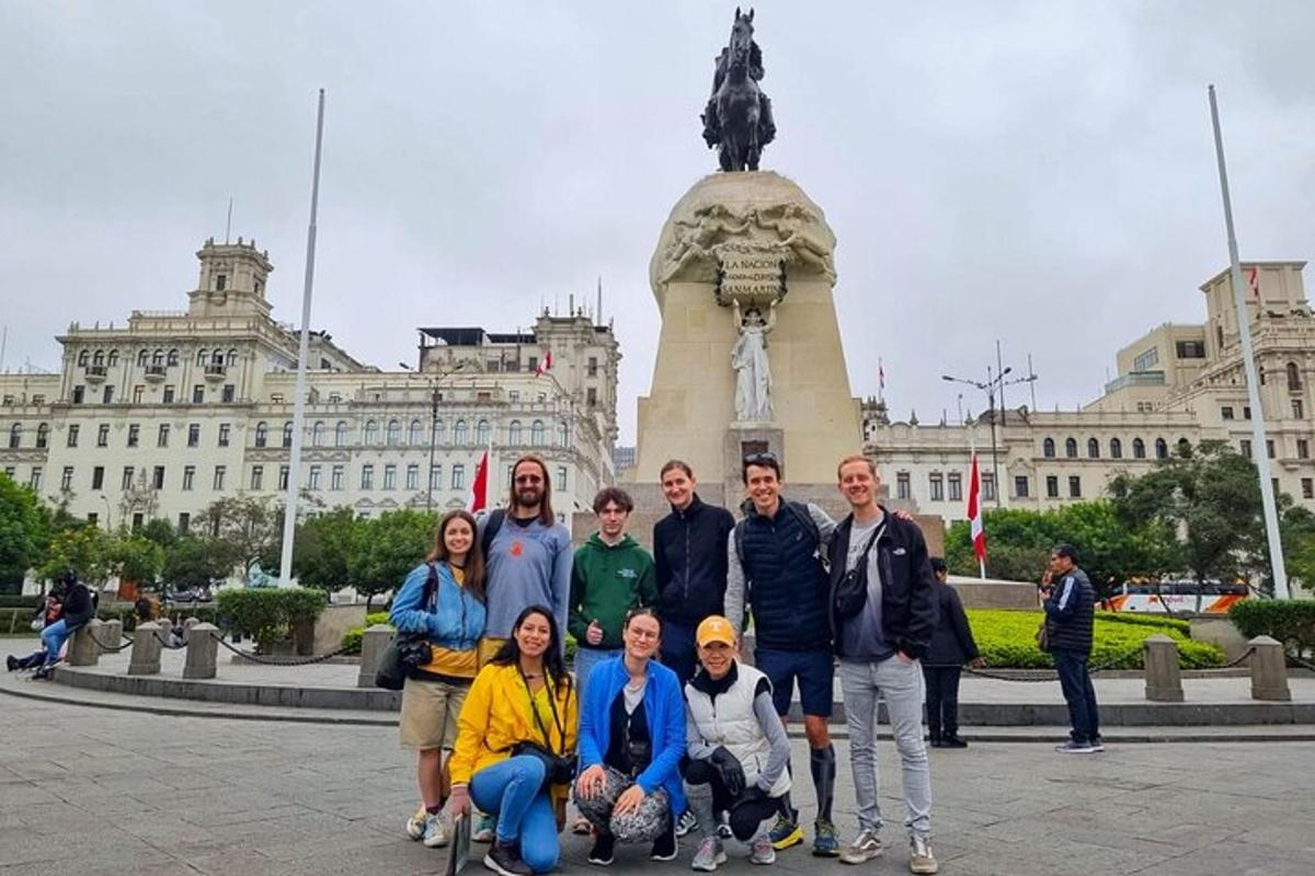 en gruppe mennesker poserer foran en statue