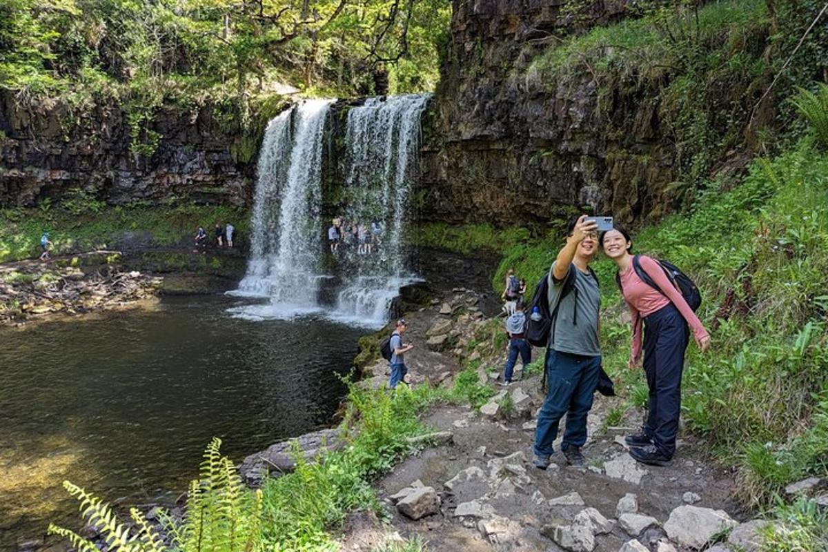 a man taking a picture of a waterfall