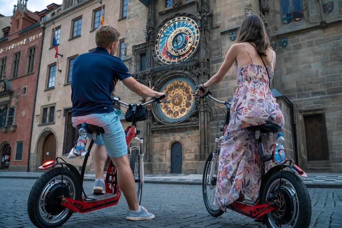 muž a žena na koloběžkách před budovou