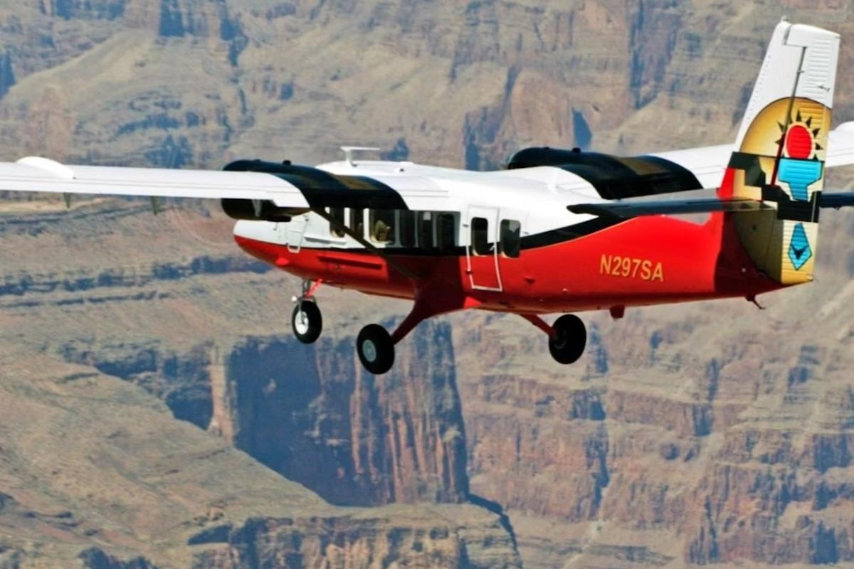ein rot-weißes Flugzeug, das über die Berge fliegt