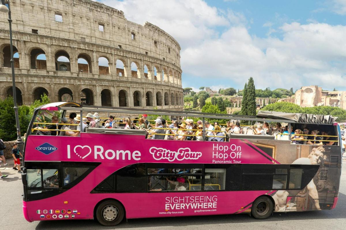růžový dvoupatrový autobus před Koloseem