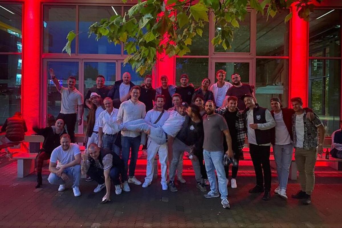 skupina lidí pózujících pro fotografii před budovou