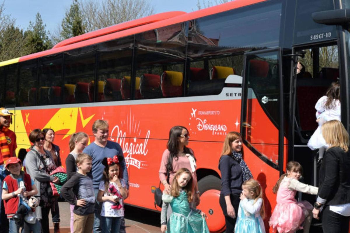 a group of people standing in front of a bus