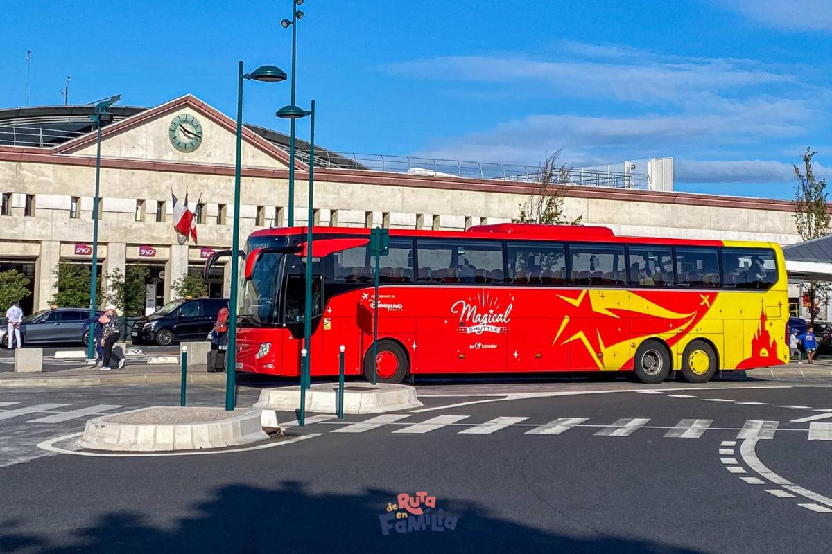a red and yellow bus parked in front of a building
