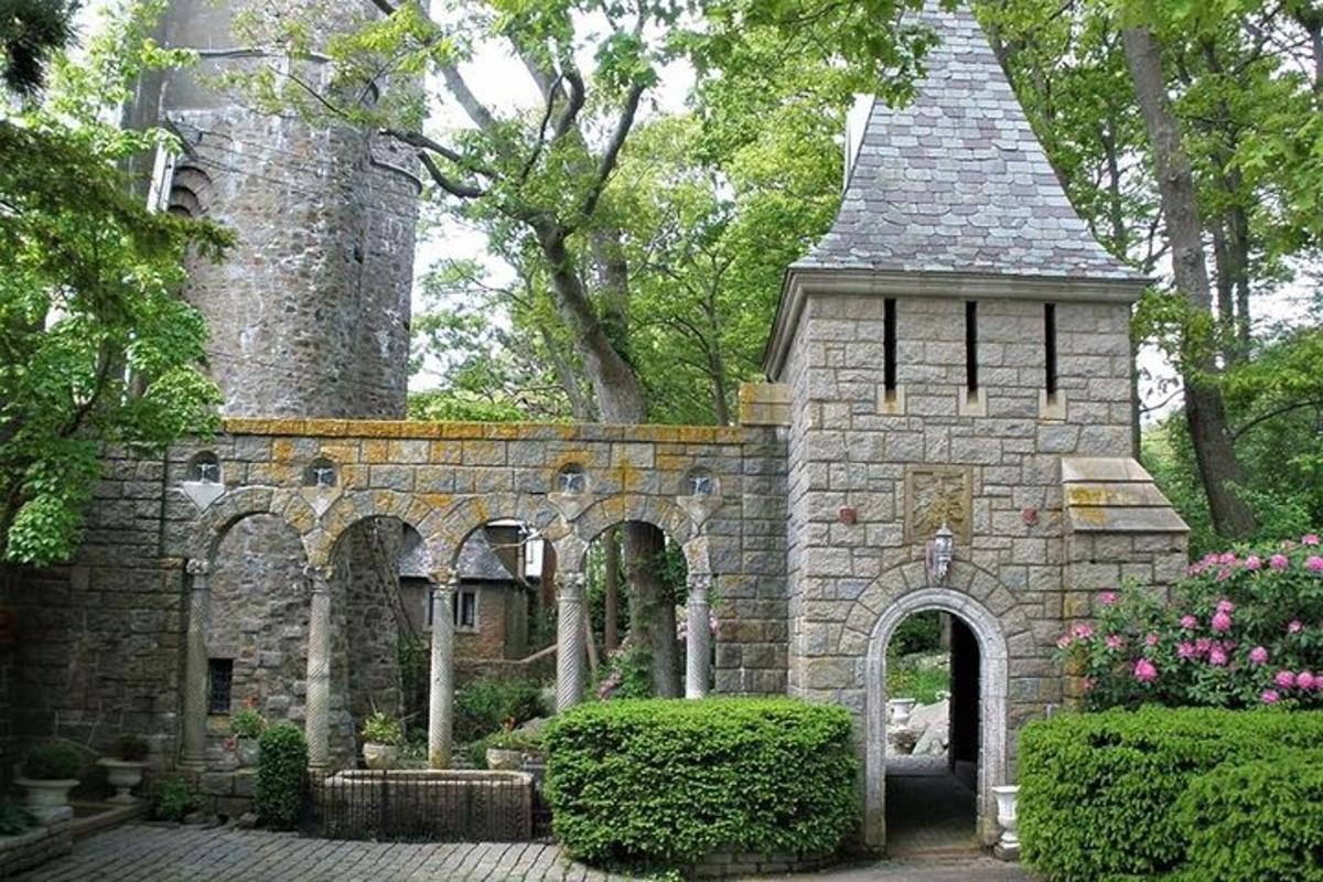 un edificio in pietra con un arco in un giardino