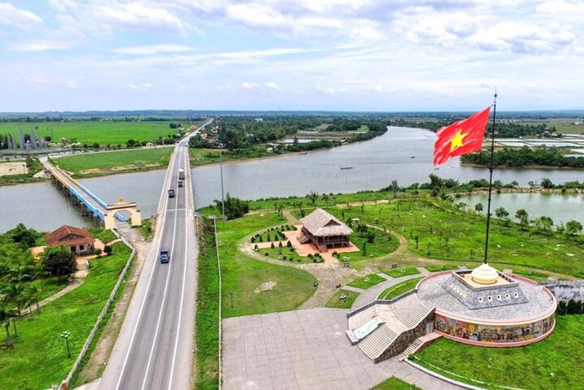 un drapeau flottant sur une rivière avec un pont