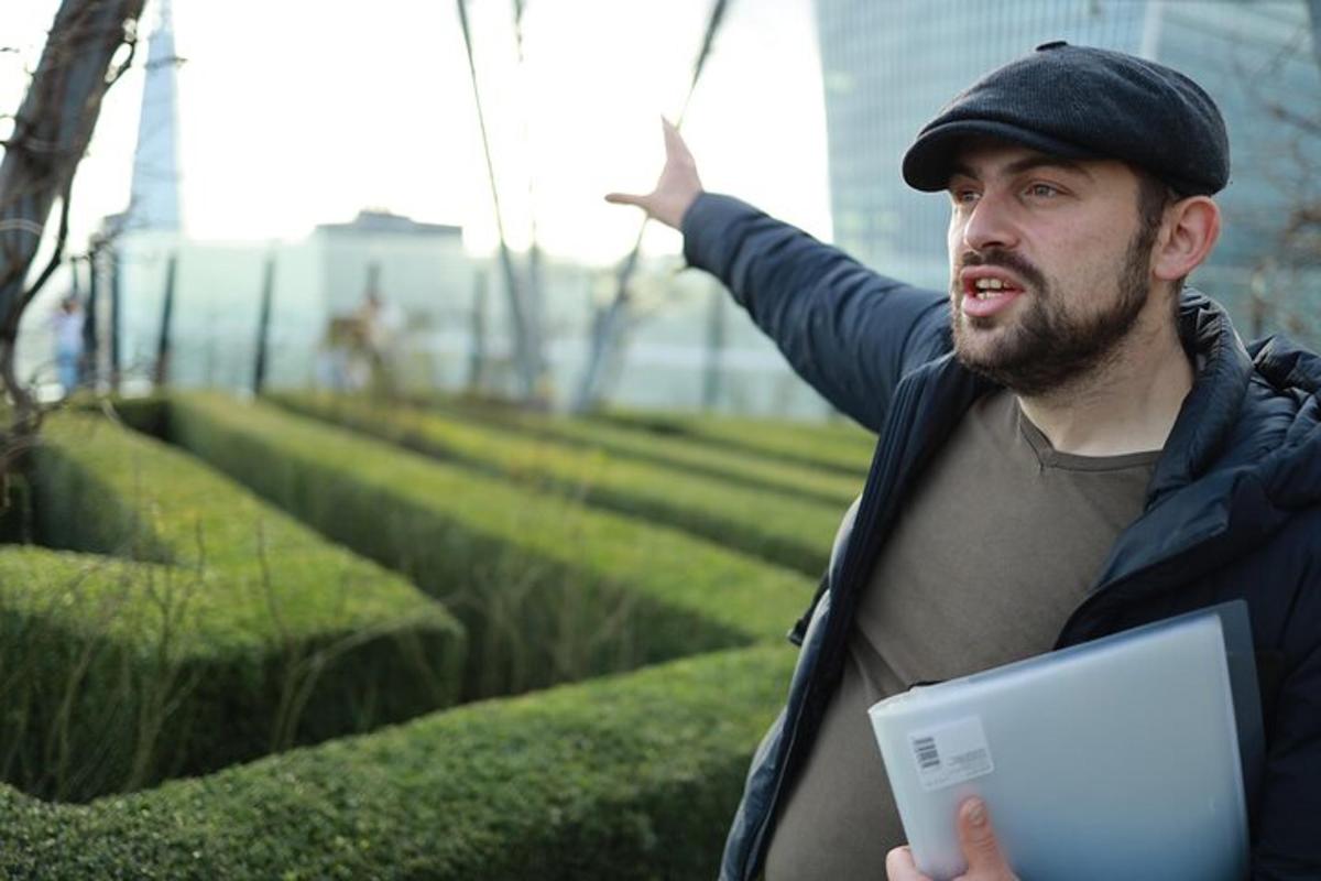 muž držící notebook v parku