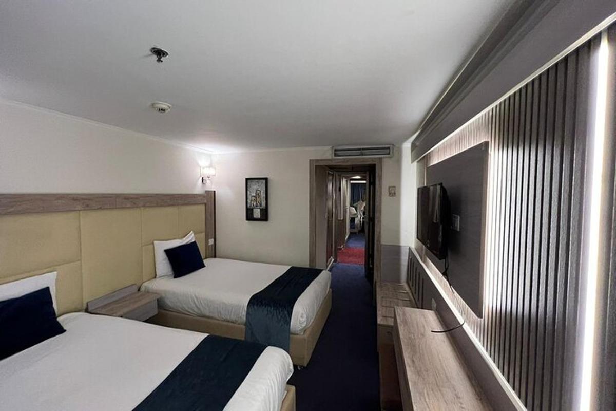 egy hotelszoba két ággyal és egy televízióval