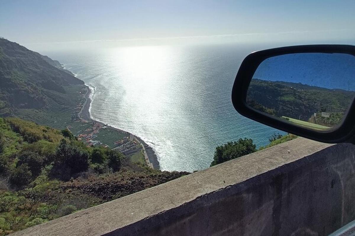 una vista de l'oceà des del mirall retrovisor d'un cotxe