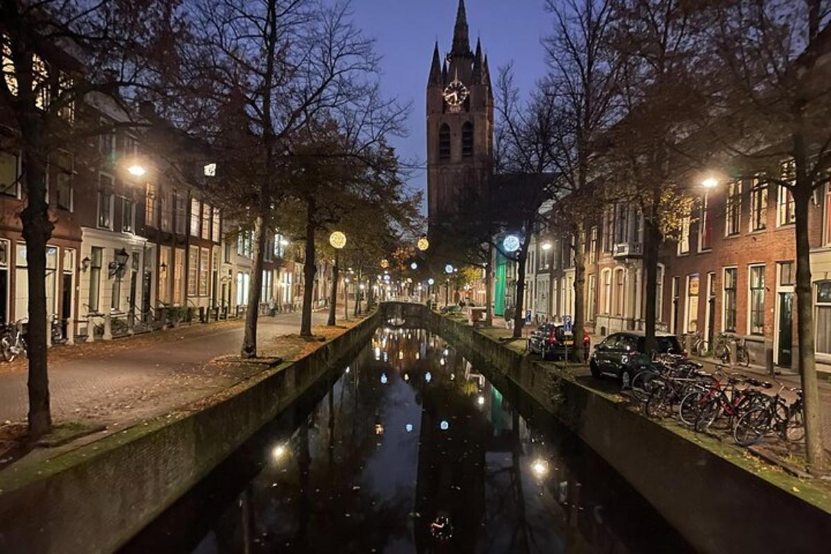 un canale in una città di notte con una torre dell'orologio