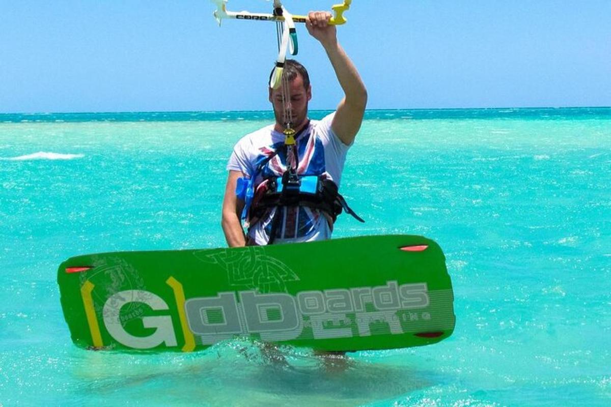 un uomo in piedi nell'oceano con una tavola