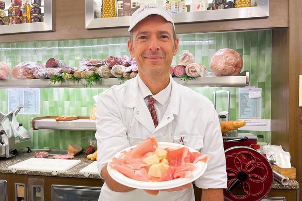 šéfkuchař držící talíř s jídlem v kuchyni