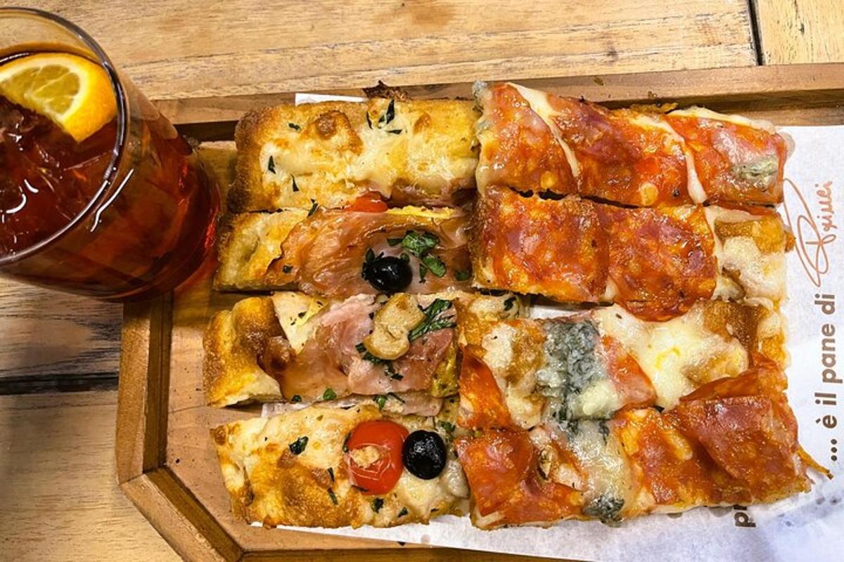 egy pizza egy fadobozban egy ital mellett
