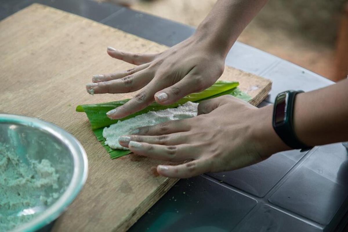 uma pessoa fazendo um sanduíche em uma tábua de corte