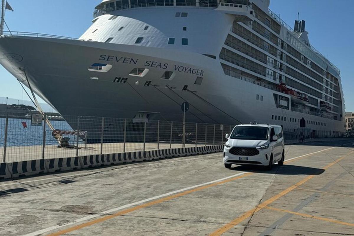 bílé auto zaparkované před výletní lodí