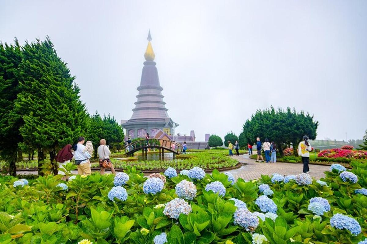 Menschen, die in einem Garten mit einer Pagode im Hintergrund spazieren gehen