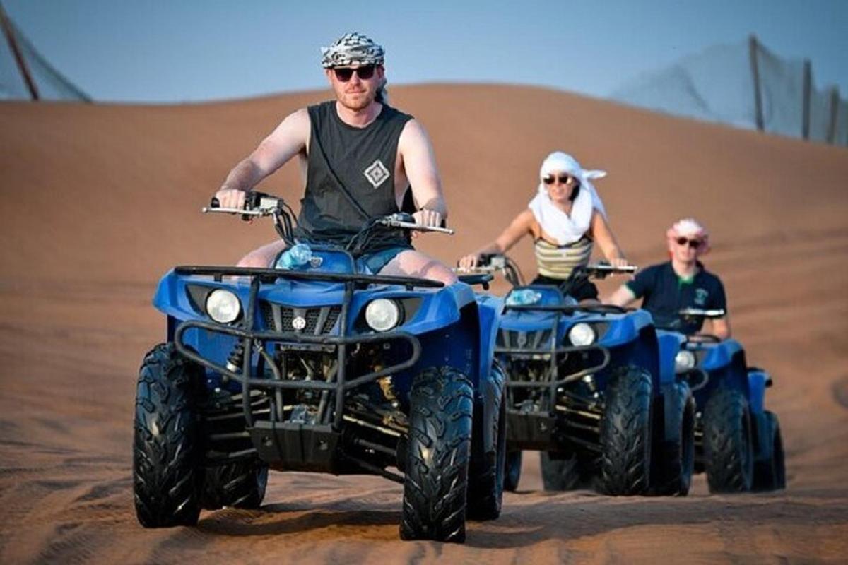 dos homes que condueixen quads al desert